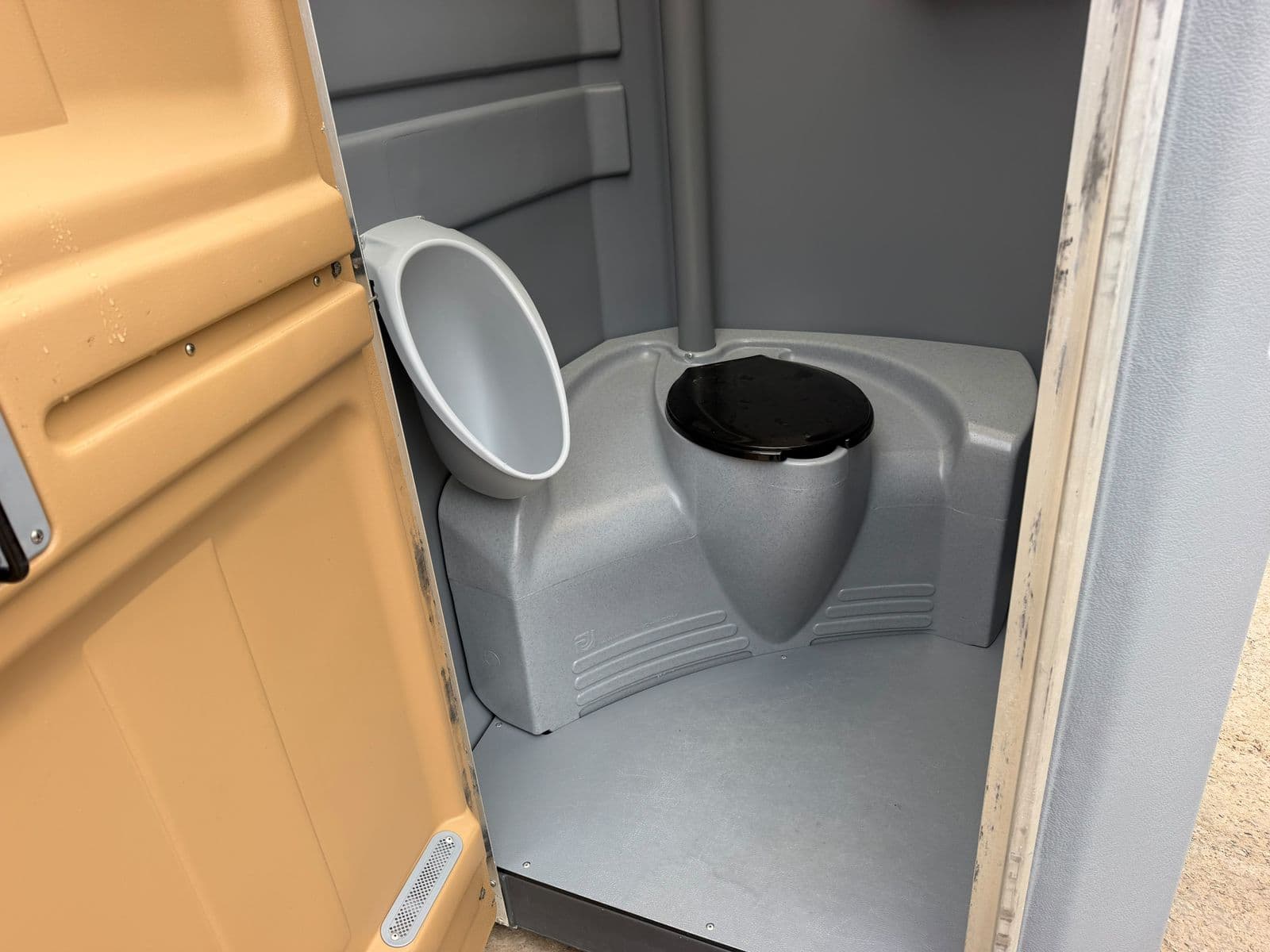 Interior of a standard portable restroom with urinal and toilet