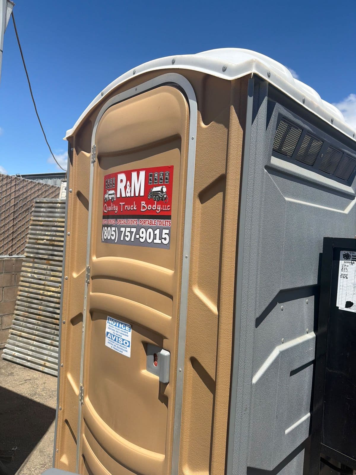 Standard tan and gray portable restroom with R&M decal